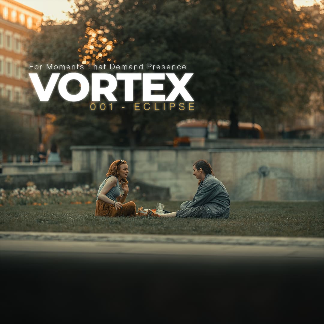 Two people sitting on grass in golden light edited with VORTEX preset from ECLIPSE Cinematic Lightroom Pack